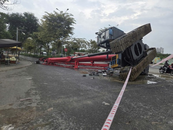 Xe cần cẩu lật khỏi xe đầu kéo ngã xuống đường, một người bị thương nặng