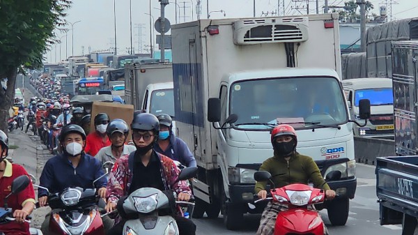 Lật xe tải chở ván gỗ, cửa ngõ phía tây TP.HCM kẹt xe nghiêm trọng