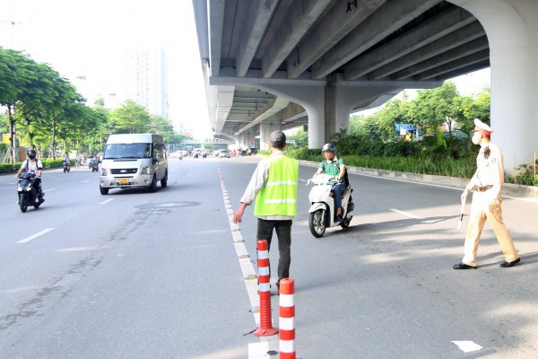 Nhiều xe máy đi sai làn sau khi dựng rào sắt trên đường Phạm Văn Đồng