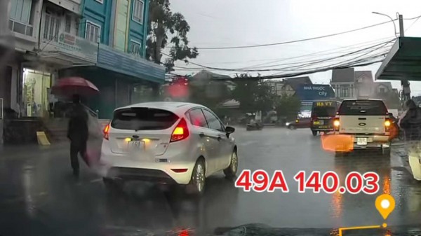Tài xế đỗ ô tô giữa đường lúc trời mưa, vô tư cầm ô đi đón khách